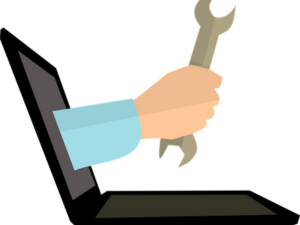 hand with wrench coming out of laptop screen