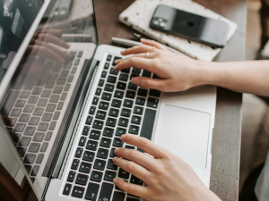 hands typing on laptop keyboard